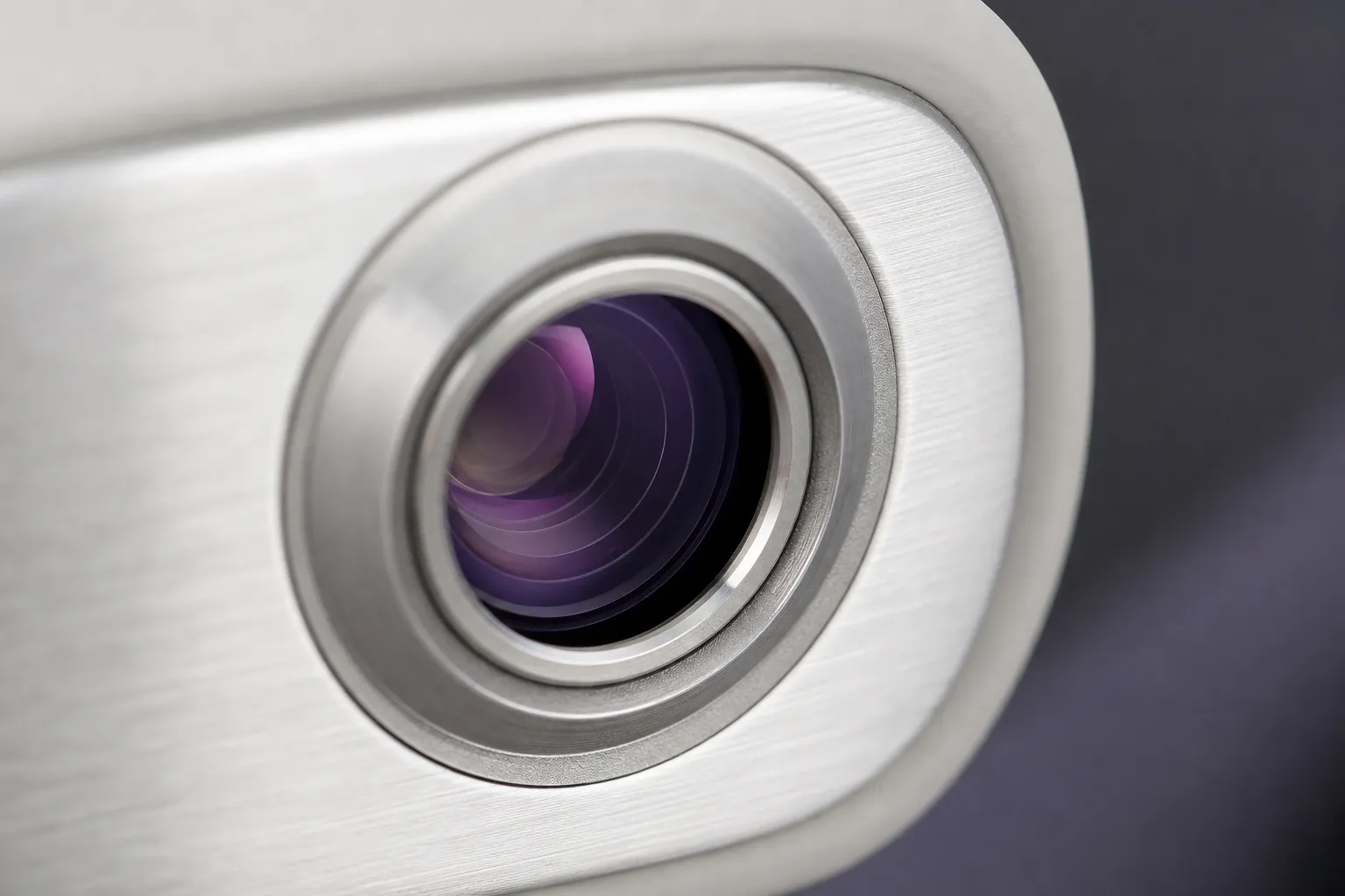 Vue macro de l’optique de sortie d’une pièce à main de laser, lentille polie dans sa bague métallique