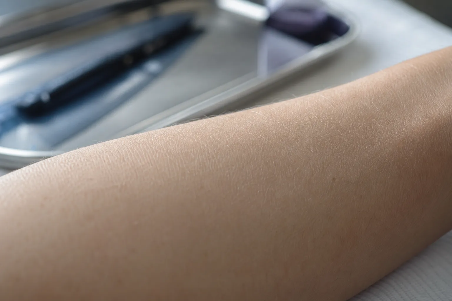 Gros plan sur la face interne d’un avant bras, peau nue sans tatouage, lumière de fenêtre